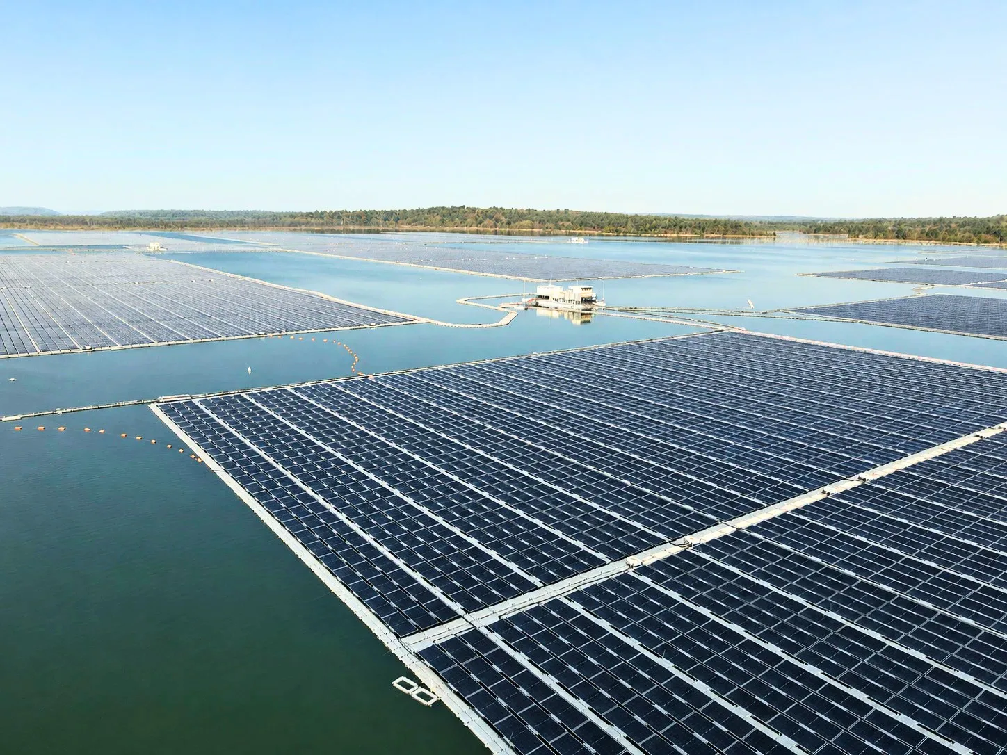 Operations and maintenance team inspecting a large floating solar array on an Indian reservoir