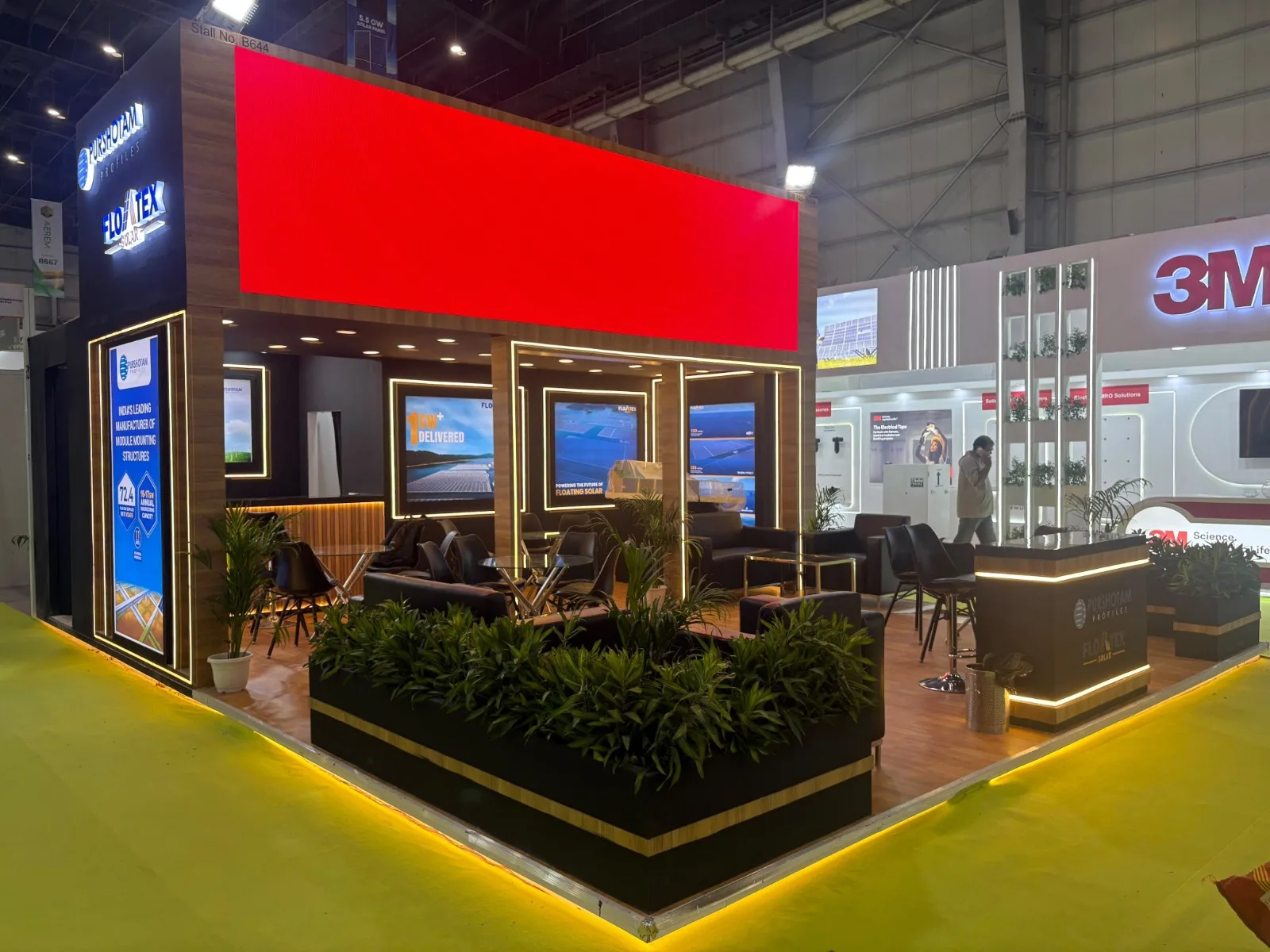 Floatex Solar booth at Renewable Energy India Expo with illuminated floating solar project displays, lounge seating and planters