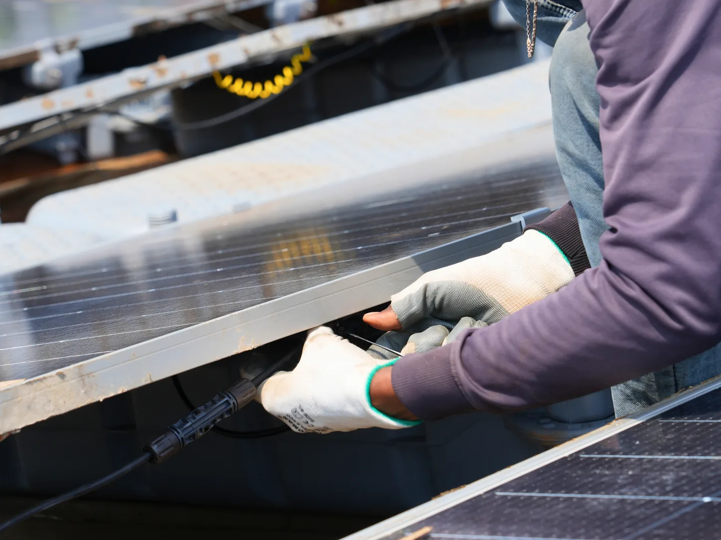 Technician connecting cabling on a floating solar array during technical due diligence